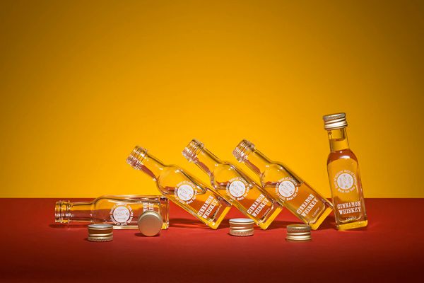 六个小的，部分开放的威士忌酒瓶彼此倾斜。